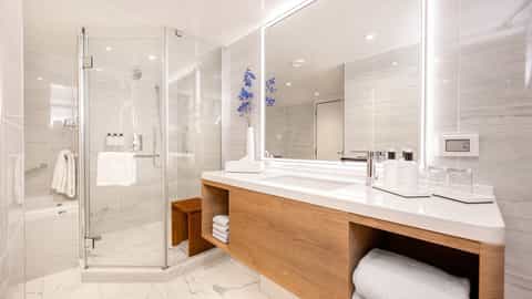 A modern bathroom with a shower and vanity - Sun Princess, Princess Cruises