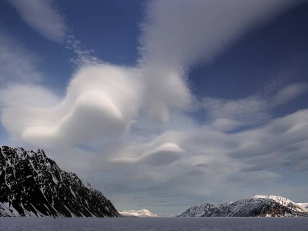 snowy mountains dramatic clouds